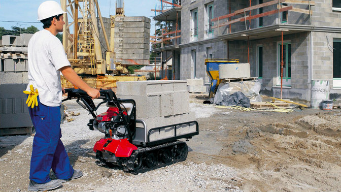 Chariot à chenilles utilisé par un opérateur, sur un chantier.