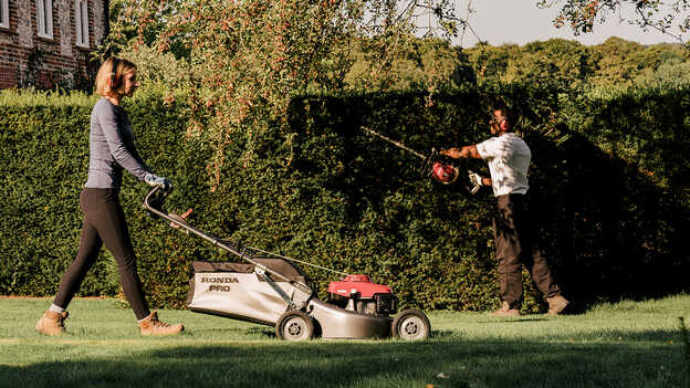 Lady cutting grass with a Honda HRH.