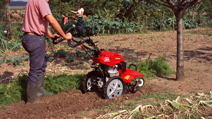 Front view of the counter-rotating tiller working the soil.