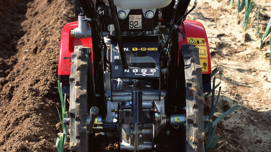 Front view of the counter-rotating tiller working the soil.