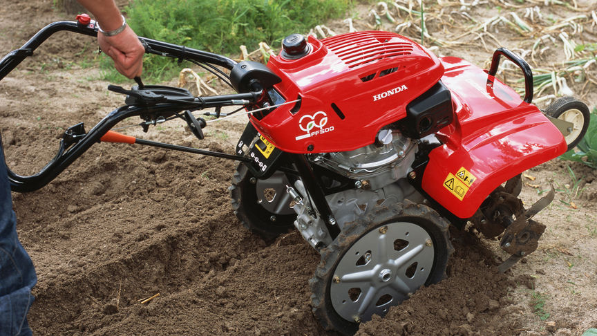 Front view of the counter-rotating tiller working the soil.